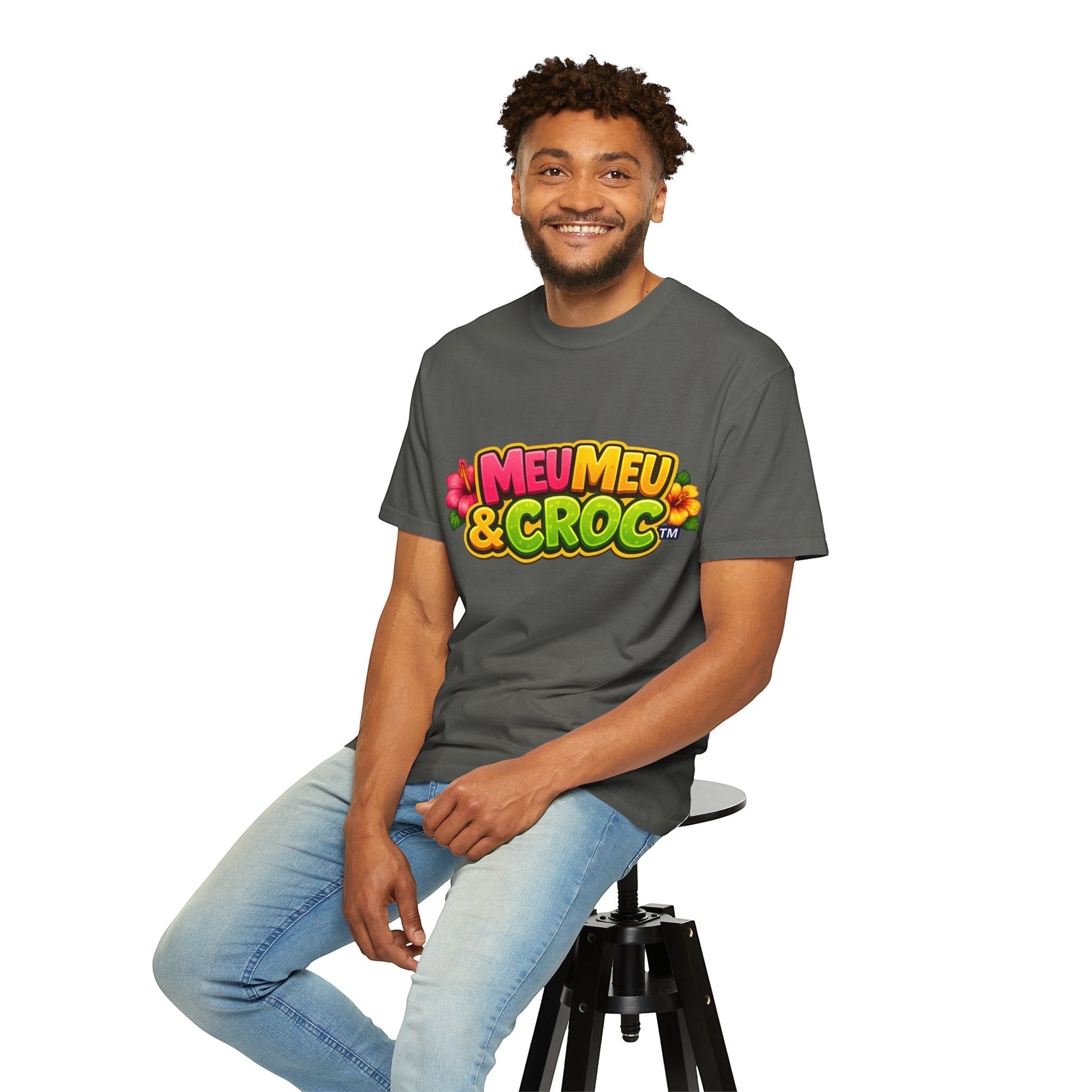 Man wearing a charcoal grey Meu Meu & Croc Tropical Store graphic t-shirt with colorful tropical floral logo design.