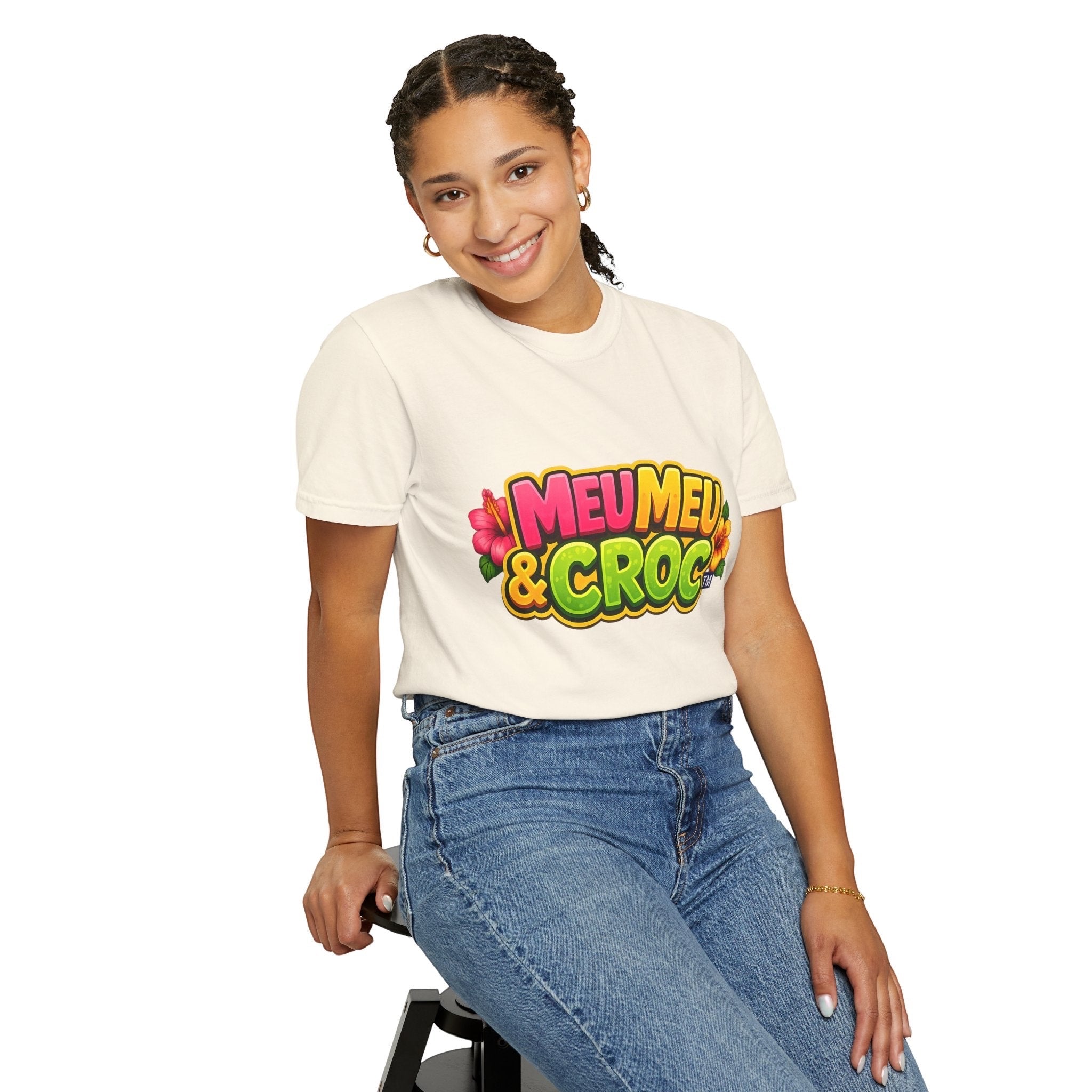 Woman wearing a cream Meu Meu & Croc Tropical Store graphic t-shirt with colorful floral logo, paired with blue jeans.