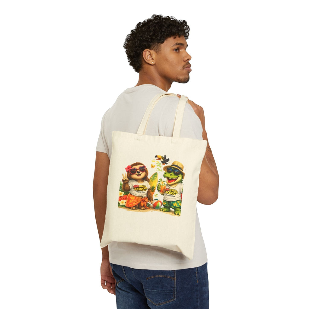 Model wearing a natural Meu Meu & Croc Tropical Store canvas tote bag with sloth and crocodile beach graphic print.